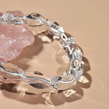 Clear quartz irregular beads arranged in infinity loop—showcasing translucency and organic contours under soft light