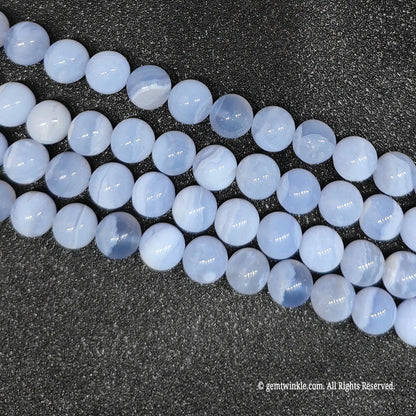 Four clean strands of dyed blue agate crystal beads highlighting surface polish and round cut over an agate base