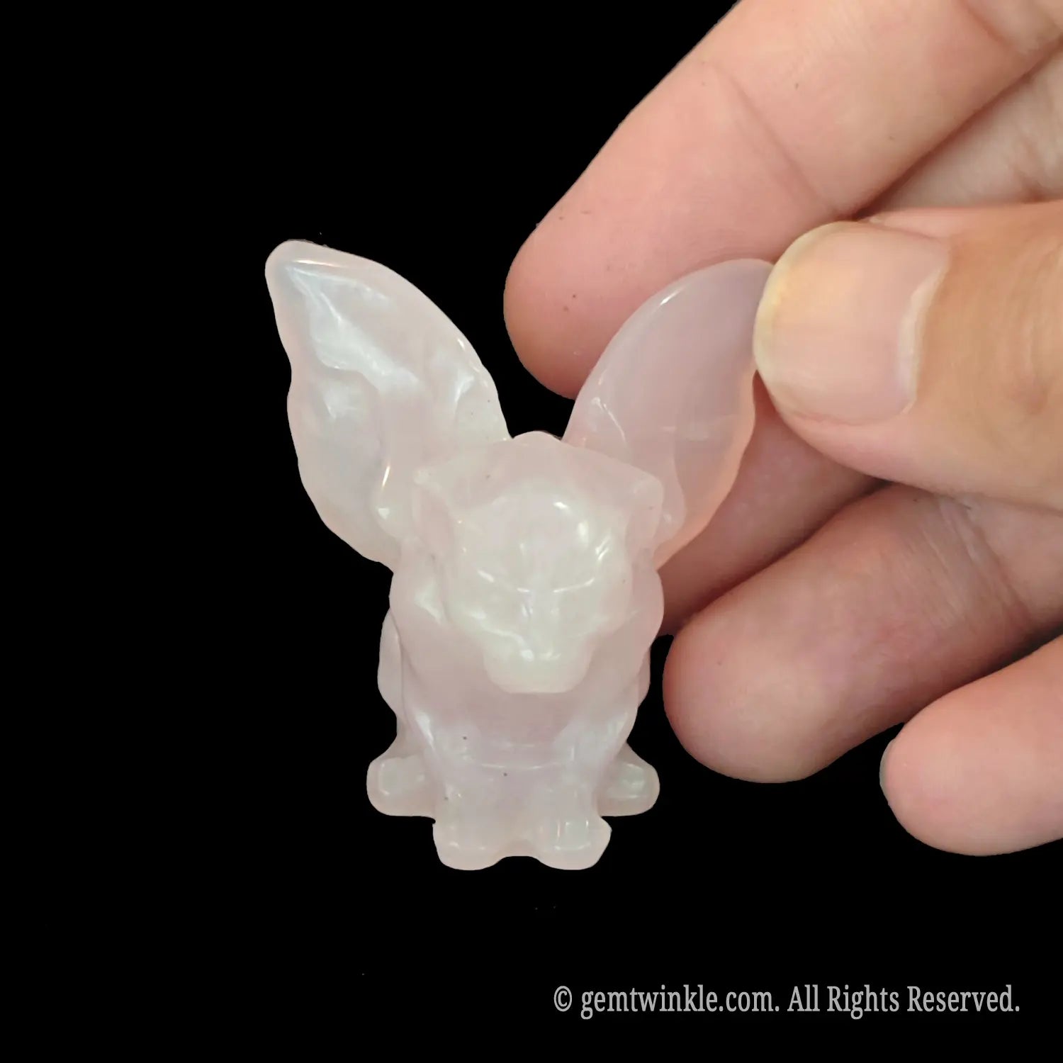 Front view of carved pink rose quartz gargoyle totem showcasing a pastel gothic look
