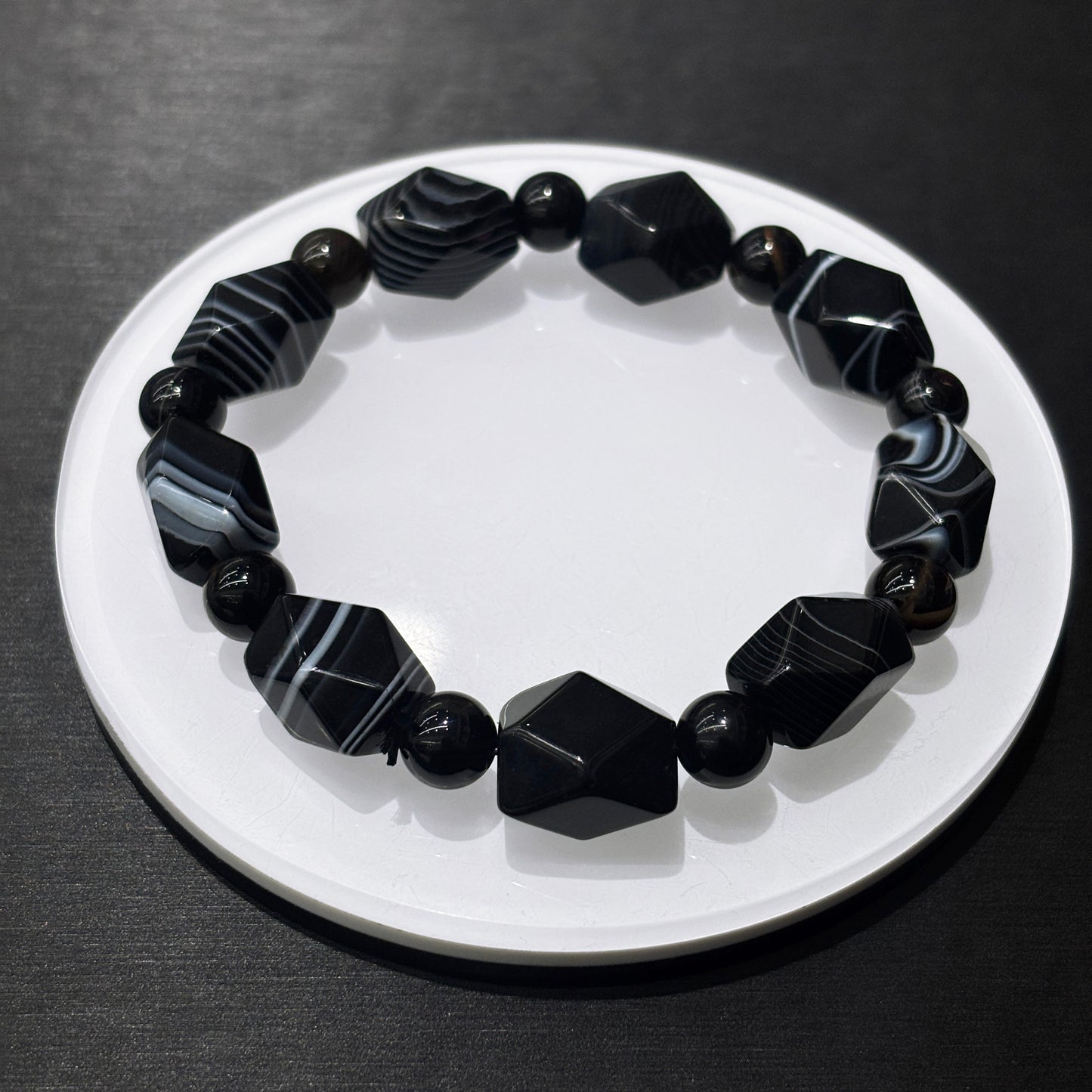 Black and white banded agate bracelet in full circle on white dish, stylish leisure wear jewelry for daily confidence