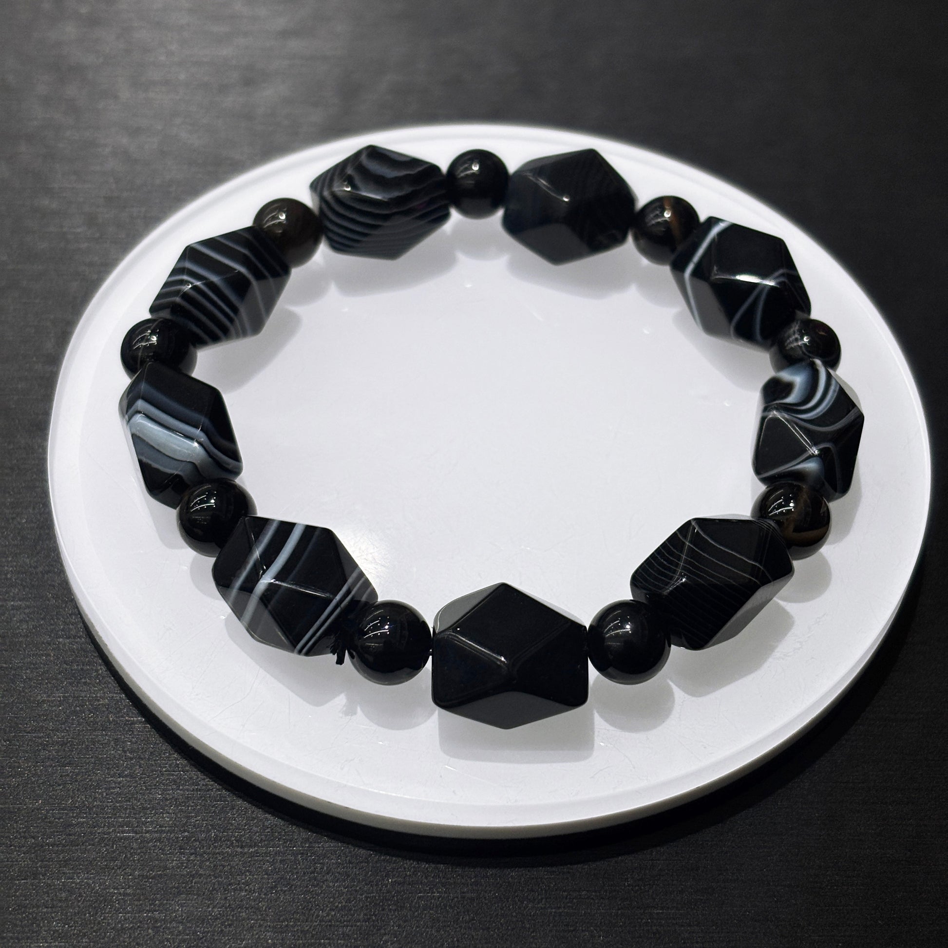 Black and white banded agate bracelet in full circle on white dish, stylish leisure wear jewelry for daily confidence
