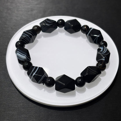 Black and white banded agate bracelet in full circle on white dish, stylish leisure wear jewelry for daily confidence