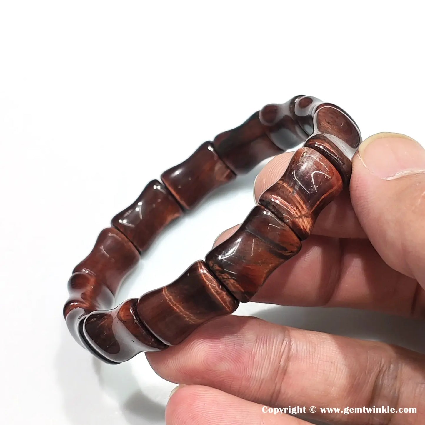 Top-down view of red tiger eye bamboo bangle in closed circle, demonstrating ergonomic fit and consistent color flow across 15mm units