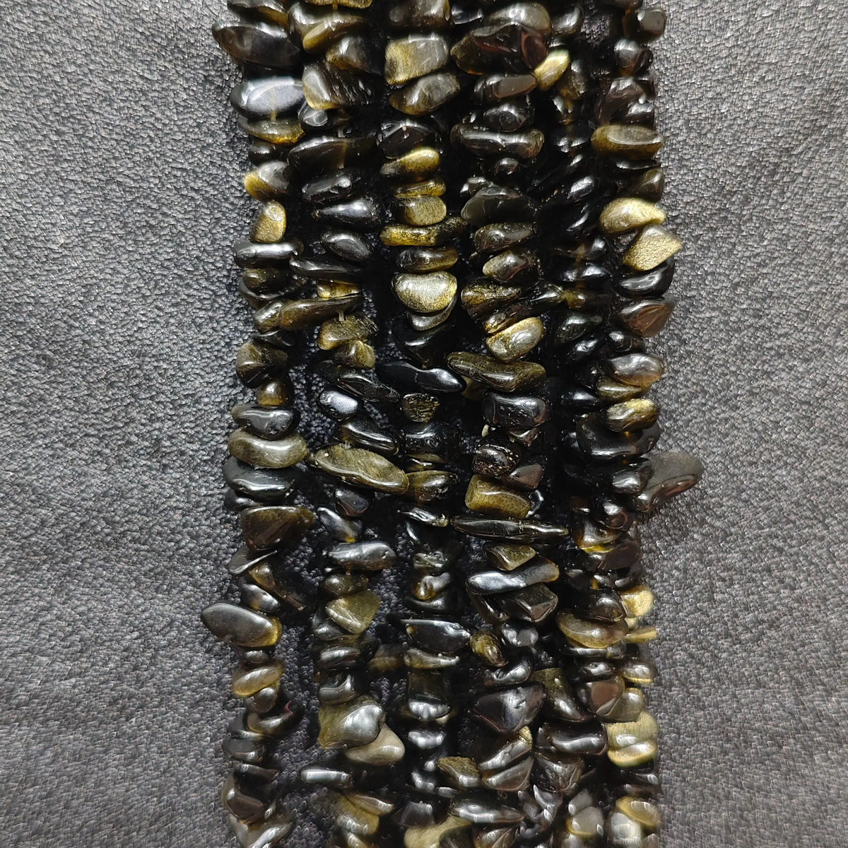 Close up of multi strands of natural golden obsidian 5-10mm irregular black and gold sheen chips[cite: 9]