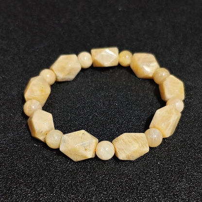 Natural yellow quartzite faceted freeform stretch bracelet held on hand displaying butterscotch honey gemstone nuggets