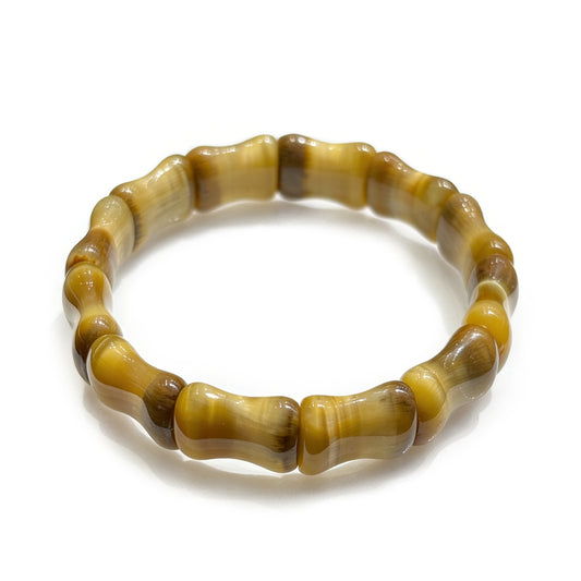 Natural golden tiger eye bamboo-shaped segmented bracelet on white background, shimmering chatoyant unisex jewelry