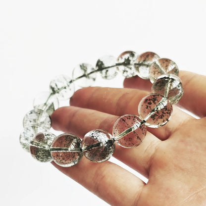 Green phantom quartz bracelet gently curved—highlighting elasticity, smooth polish, and dense green phantom patterns