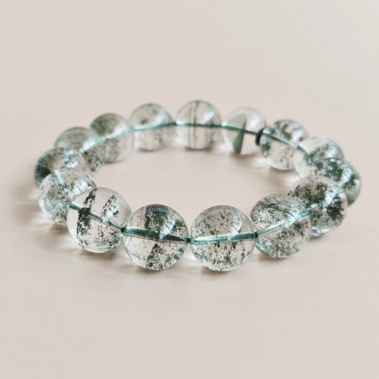Natural green phantom quartz beads, ~15mm, with vivid layered green inclusions in clear crystal—stretch elastic, displayed flat