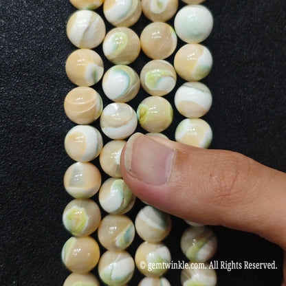 Detailed shot of green swirl sea shell loose round beads ideal for Etsy artisans and DIY jewelry design