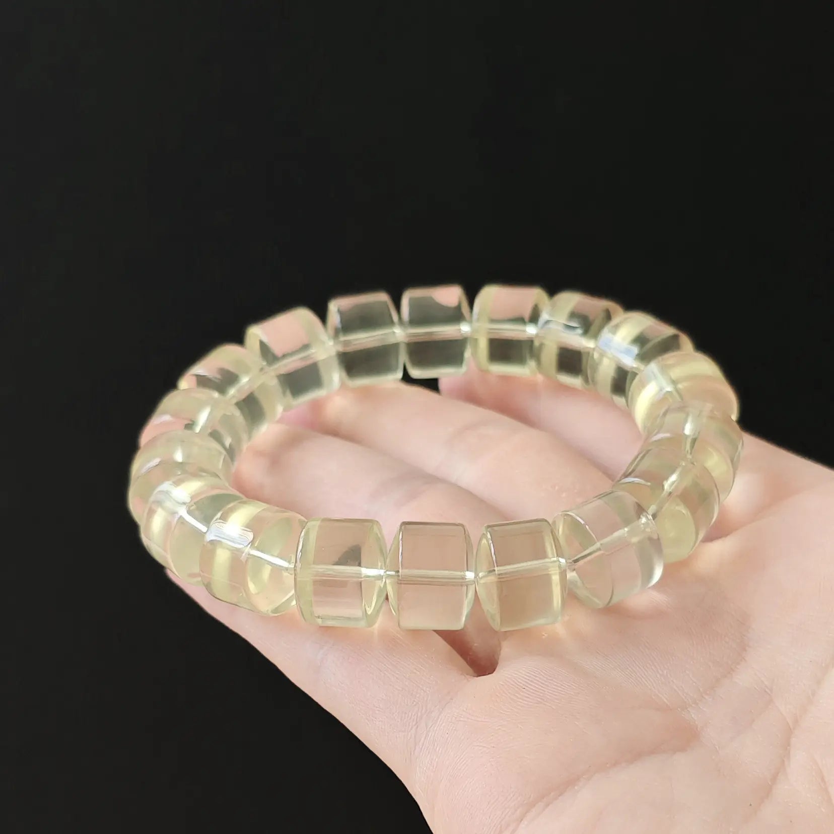 Women’s lemon citrine wheel bracelet held flat in palm—showing uniform shape, bright yellow hue, and clean transparency