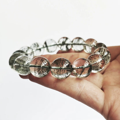 Men’s green phantom quartz bracelet held in palm—showing uniform green layers, clarity, and bead size under neutral light