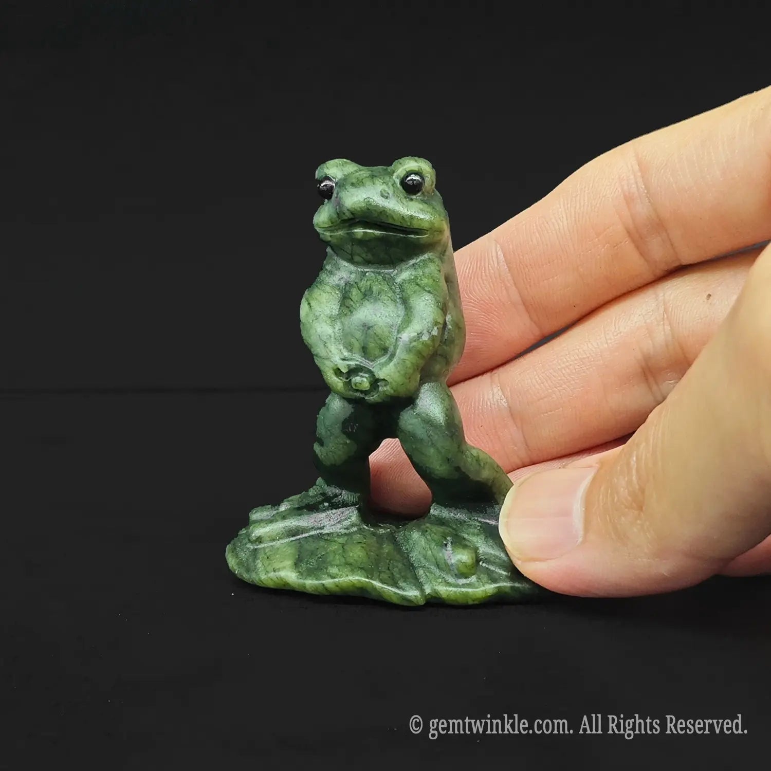 Hand holding a six centimeter funny peeing frog meme figurine to show the actual size scale for crystal wholesale buyers