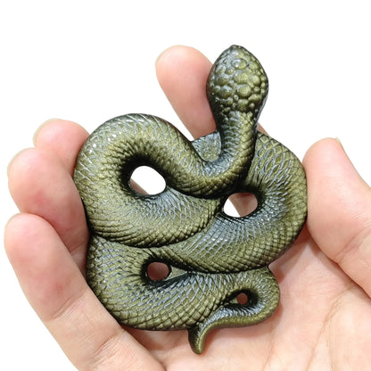 Front view of natural golden obsidian snake desk decor resting in hand highlighting size and golden metallic flash