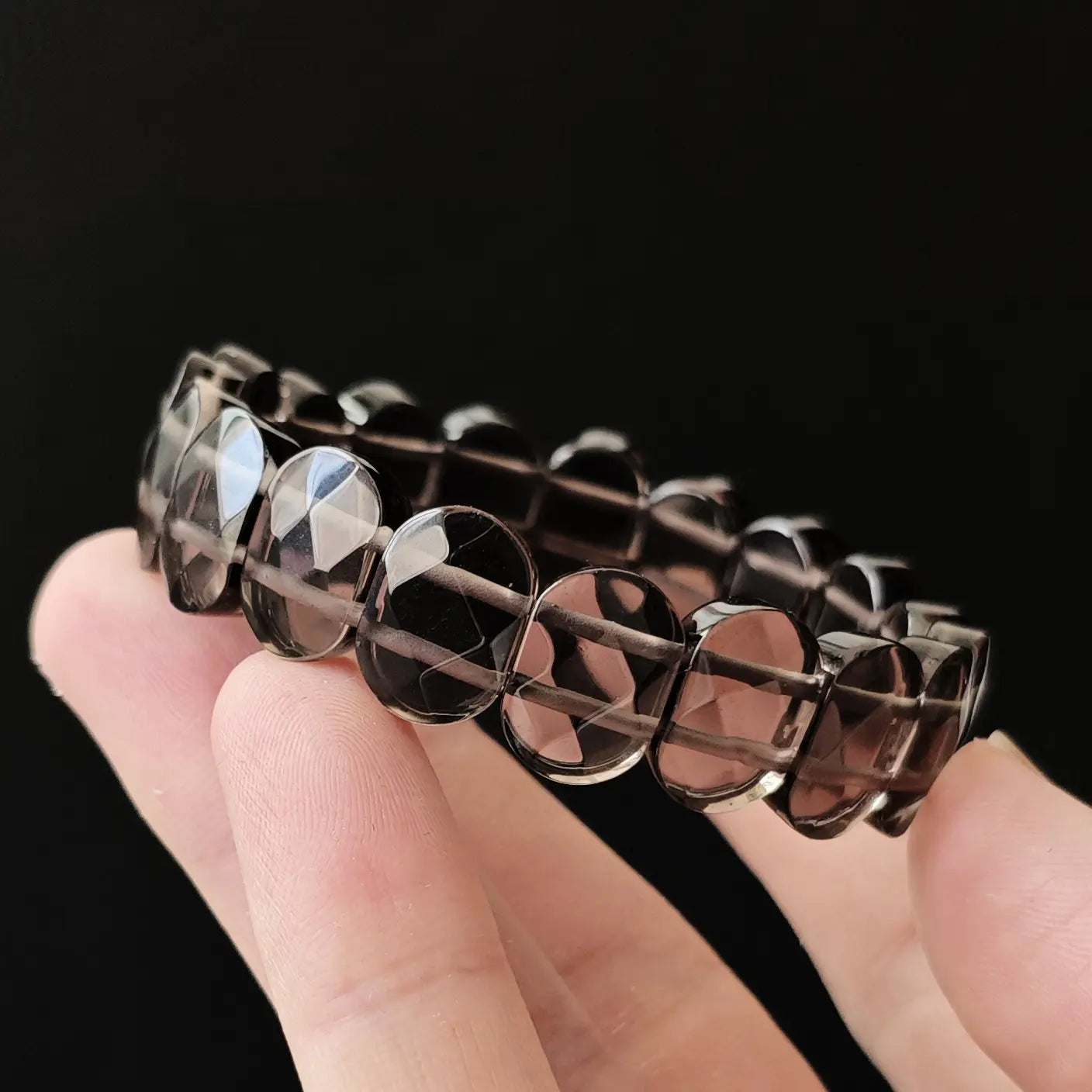 Clear ice obsidian oval beads with precise geometric faceting, revealing internal transparency; stretch crystal bracelet for mindful daily wear, non-toxic elastic cord