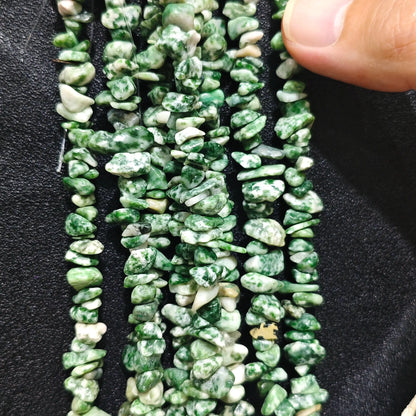Close up of multi strands of natural kiwi jasper 5-10mm irregular green speckled chips