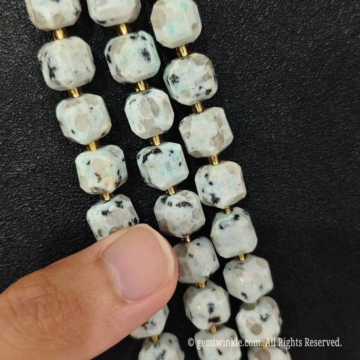 Detailed macro view of natural kiwi jasper geometric cube beads showcasing speckled organic patterns