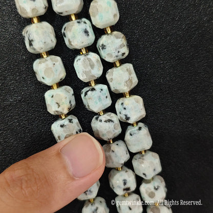Detailed macro view of natural kiwi jasper geometric cube beads showcasing speckled organic patterns