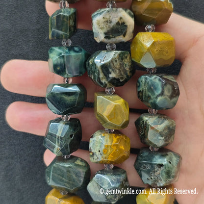 Close up view of natural ocean jasper faceted chunky beads highlighting green and yellow orbicular eyes and facets