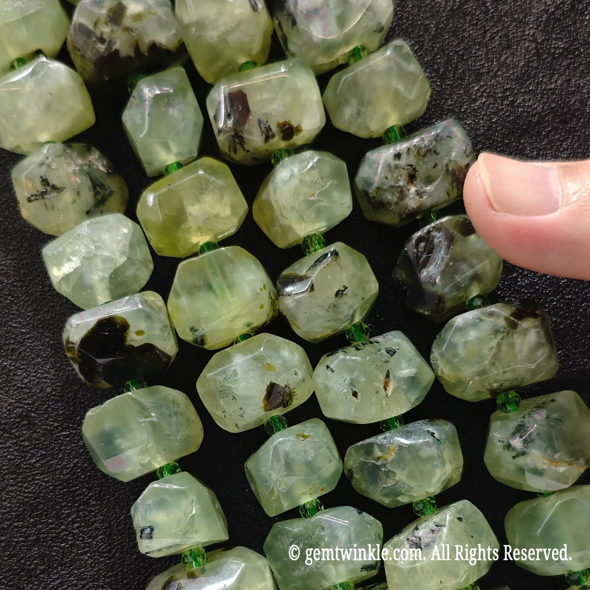 Close up view of natural green prehnite freeform faceted nugget beads with organic natural inclusions on a bead strand