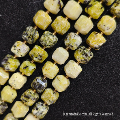 Multiple parallel strands of natural yellow jasper soft-tumbled cube beads viewed from distance