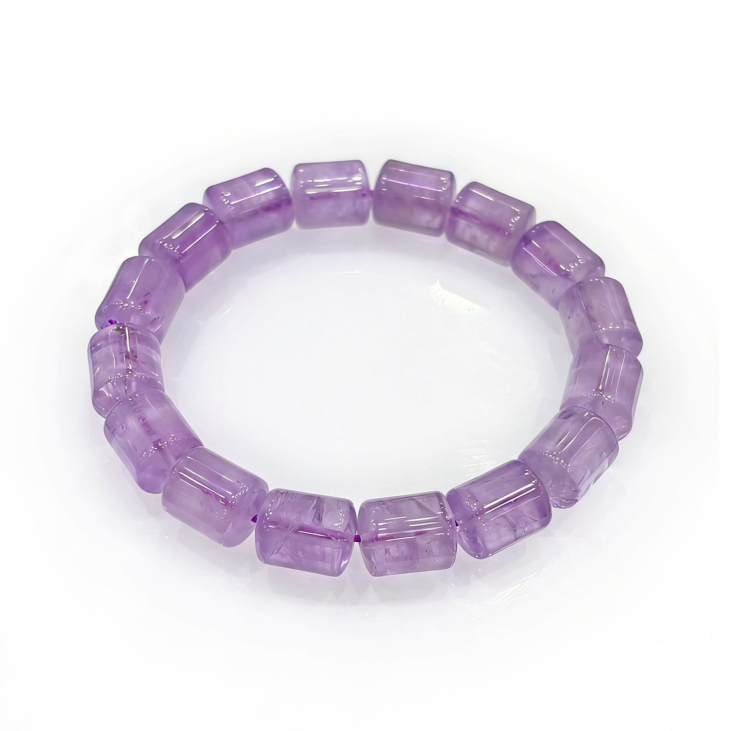 Light purple amethyst crystal bracelet with uniformly cut rectangular barrel-shaped beads, displayed in a circular arrangement on a clean white surface.