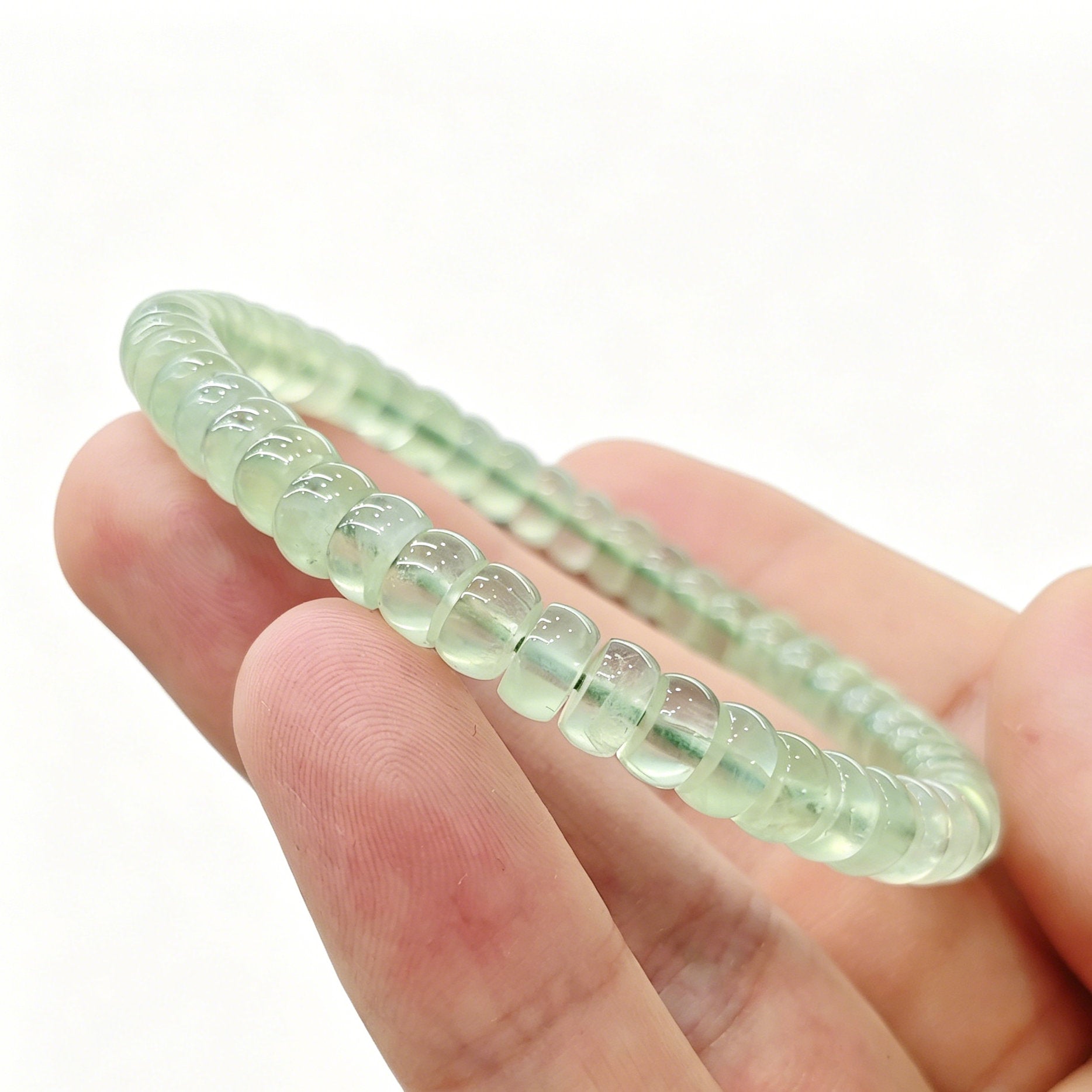 Prehnite tablet bracelet resting on palm—highlighting delicate size, soft green hue, and natural clarity