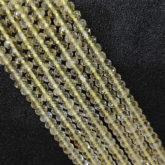 Macro closeup of lemon quartz faceted rondelle beads displaying bright yellow tone and facets