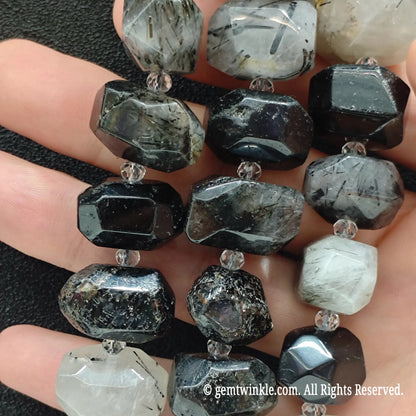 Close up perspective of multiple natural milky black rutilated quartz faceted freeform bead strands showing smooth polish