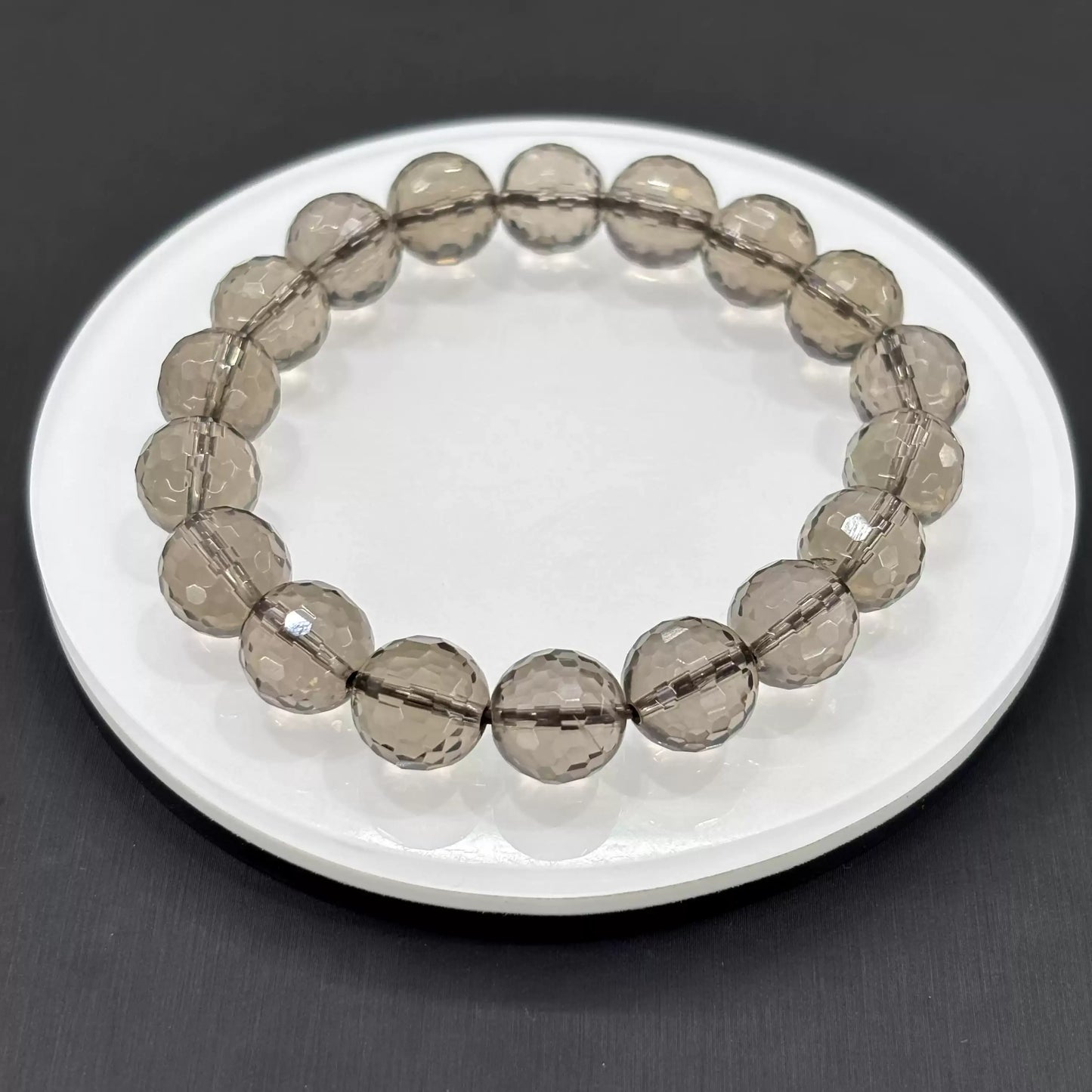 Clean presentation: uniformly faceted smoky quartz beads strung on elastic cord—no metal, no spacers, pure stone