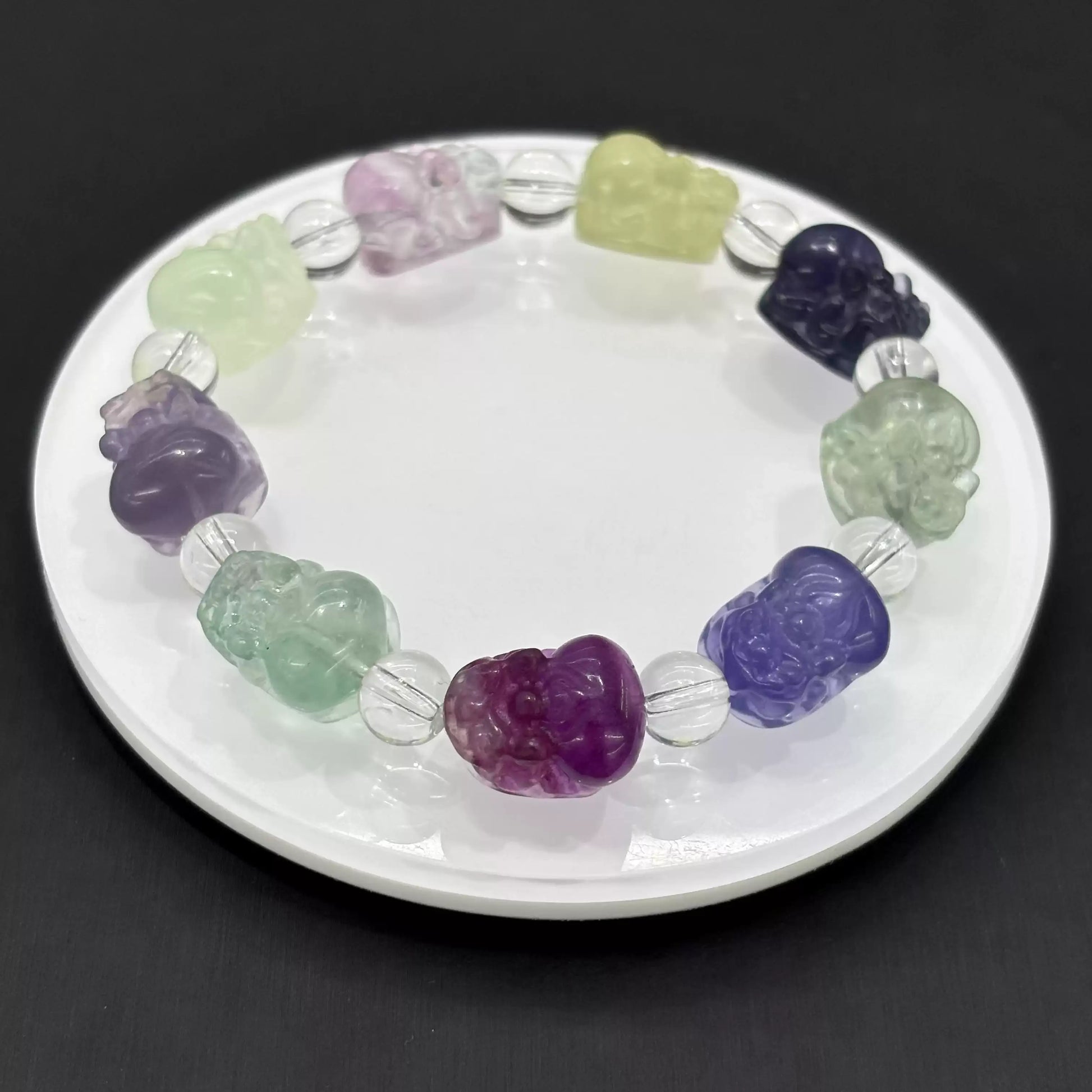 Clean presentation: fluorite Pi Xiu beads strung with clear faceted spacers on elastic cord—no metal components