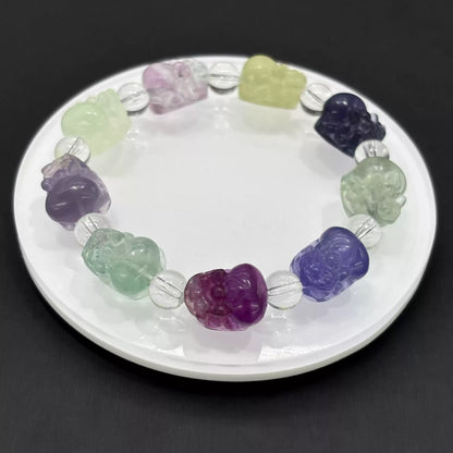 Clean presentation: fluorite Pi Xiu beads strung with clear faceted spacers on elastic cord—no metal components