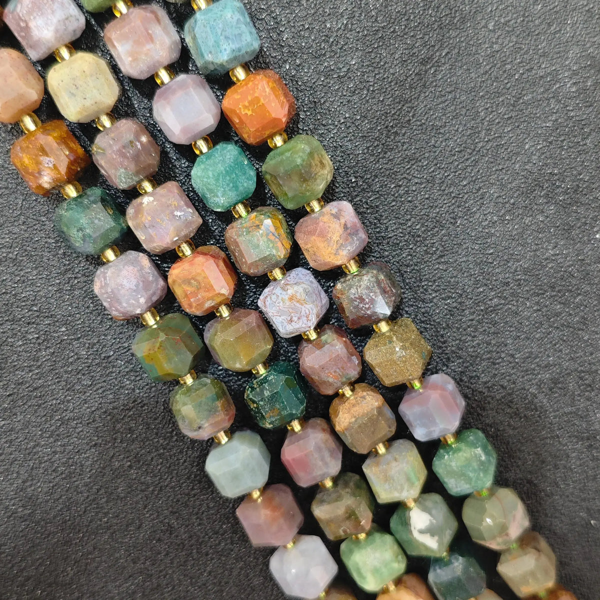 Close up of multi strands of natural multi-color ocean jasper soft-tumbled geometric cube beads showing overall strand layout[cite: 8]