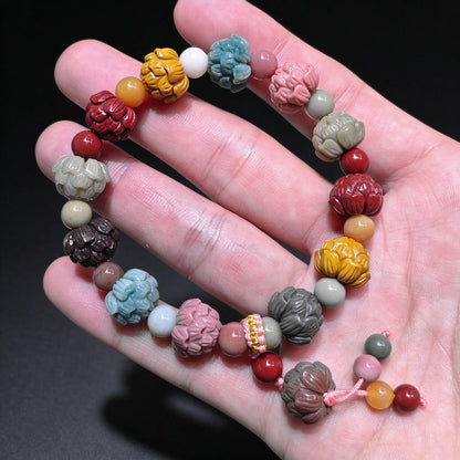 Hand holding a natural multi color Alxa agate lotus carved bead bracelet displaying colorful lotus buds and drawstring closure