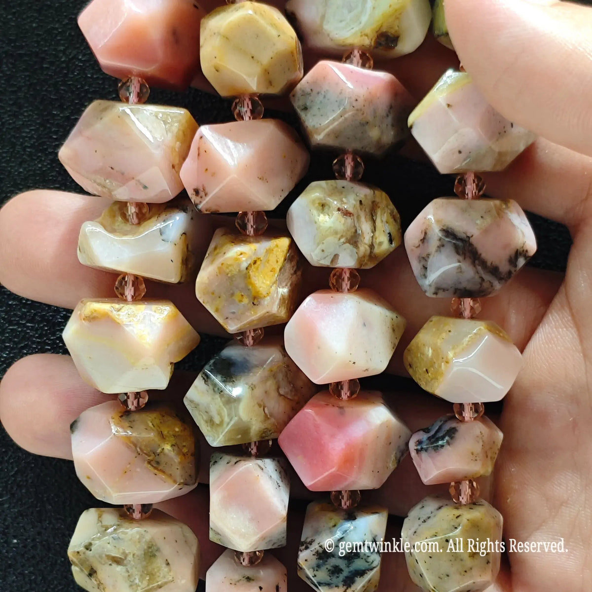 Close up of multiple strands of natural faceted pink andean opal pebble beads for handmade beading supplies