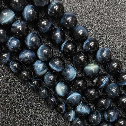 Close up of natural blue tigers eye gemstone beads showing strong cat eye chatoyancy