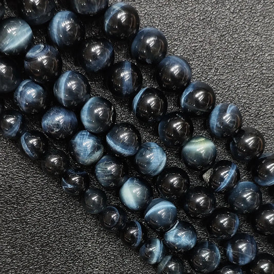 Close up of natural blue tigers eye gemstone beads showing strong cat eye chatoyancy