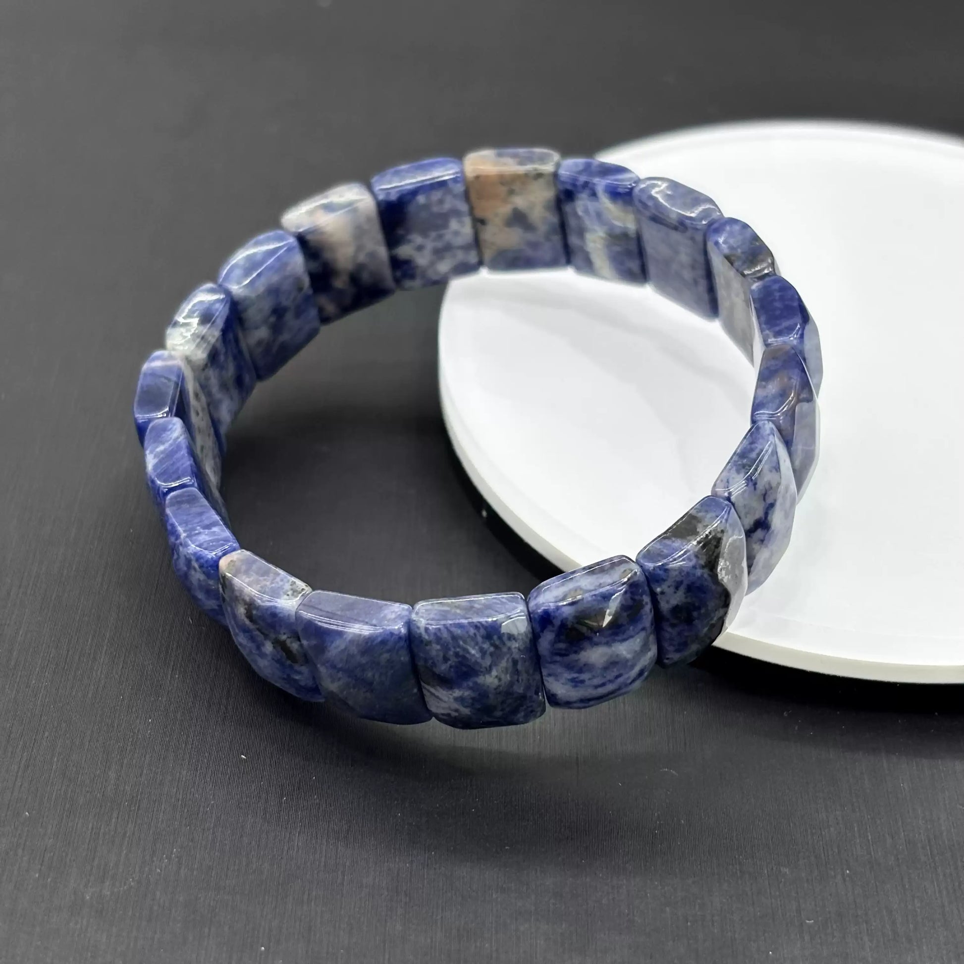The white streaks are inherent mineral inclusions in sodalite—formed geologically, not applied. Each bead is one-of-a-kind