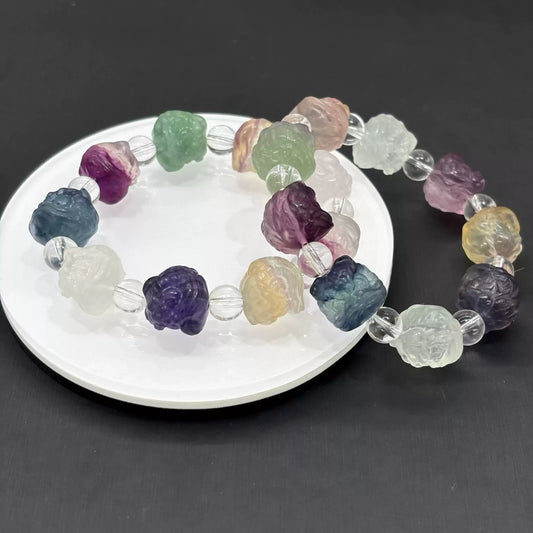 Each fluorite lion bead displays unique color zoning—purple, green, blue, yellow, pink, and white tones occur naturally