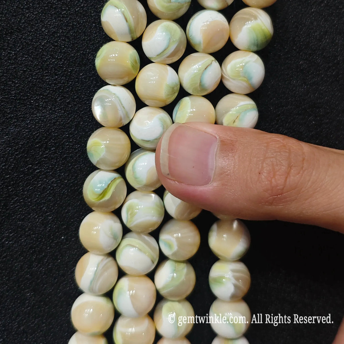 Strands of green swirl mother of pearl round beads aligned together for handmade jewelry making supplies