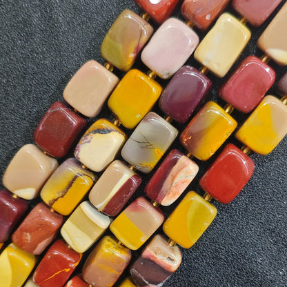 Multiple strands of natural Mookaite Jasper square beads showing vibrant yellow red and purple earth tones