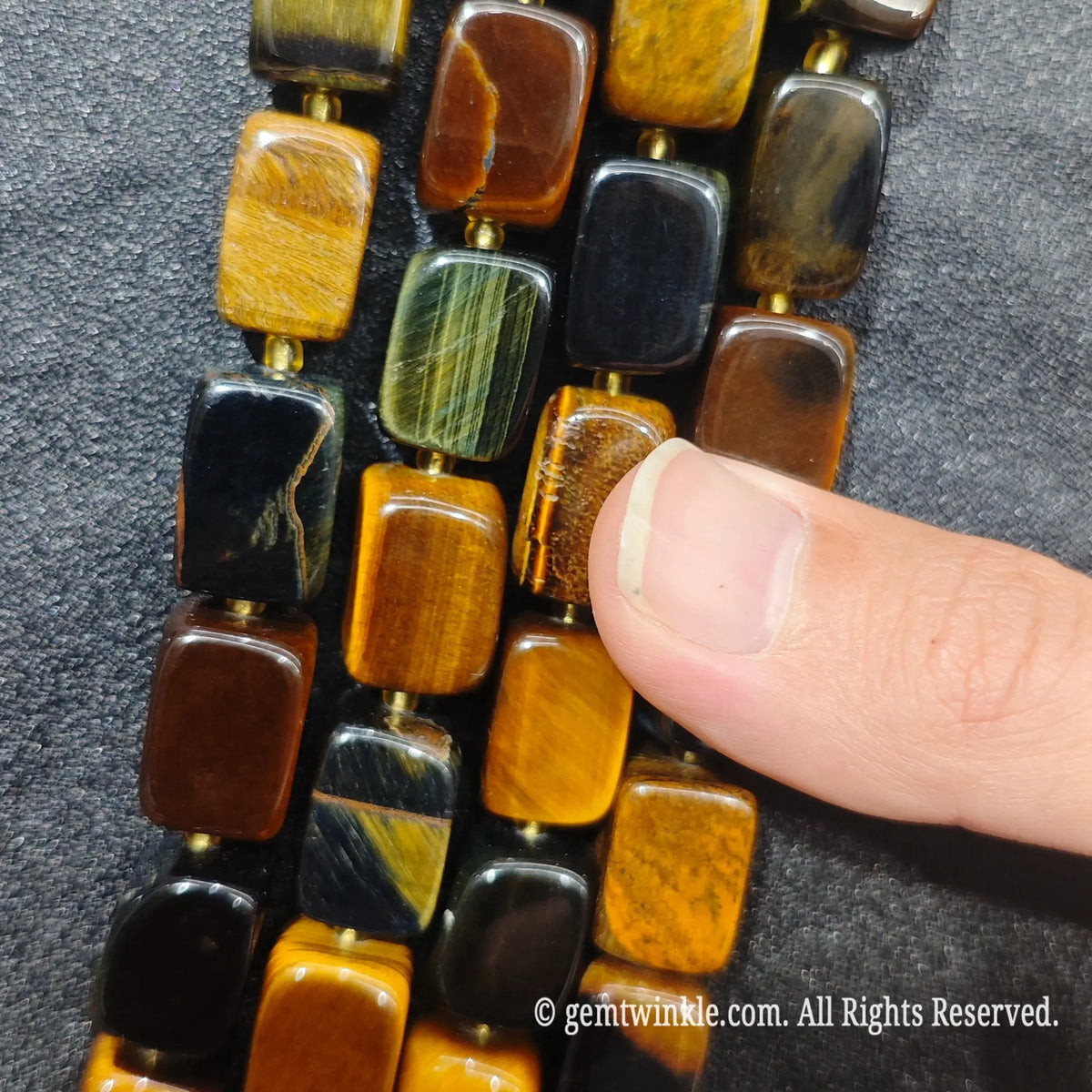 Strands of natural tiger eye and hawk eye mixed pillar beads aligned side by side showing rich earth and blue tones
