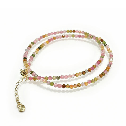 Natural multicolor tourmaline faceted round beads (3mm) in dual-layer wrap bracelet, gold-toned chain with heart charm on white background