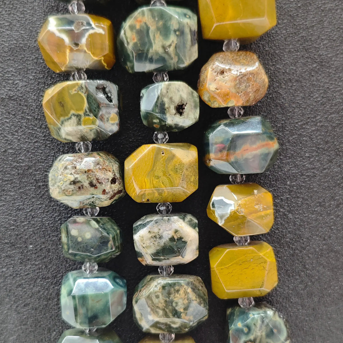 Strands of natural ocean jasper orbicular faceted chunky beads displaying yellow green and brown mineral patterns