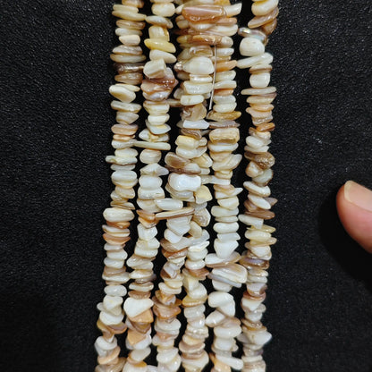 Close up of multi strands of natural shell 5-10mm irregular white and beige pearlescent chips[cite: 8]