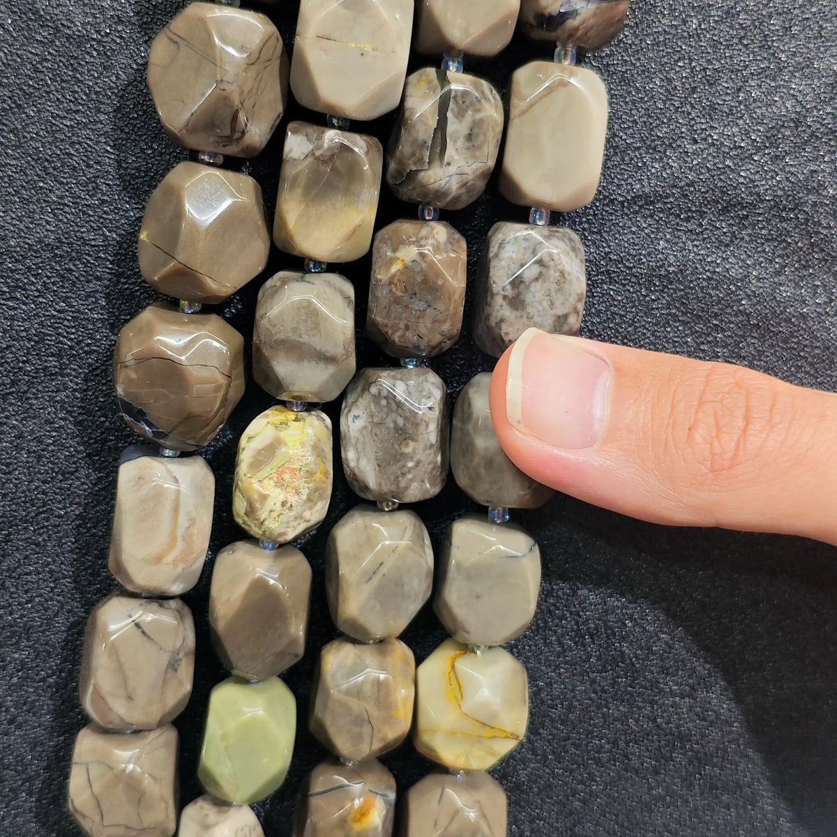 Multiple strands of natural volcanic ash agate freeform nugget beads showing muted earthy gray and khaki shades