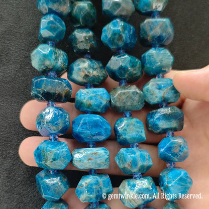 Close up perspective of multiple natural neon blue apatite faceted freeform bead strands showing smooth polished finish