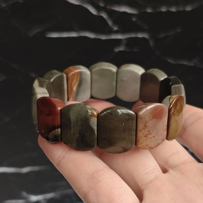 Close-up of ocean jasper bracelet held in hand—showcasing layered circular patterns and smooth polished surface