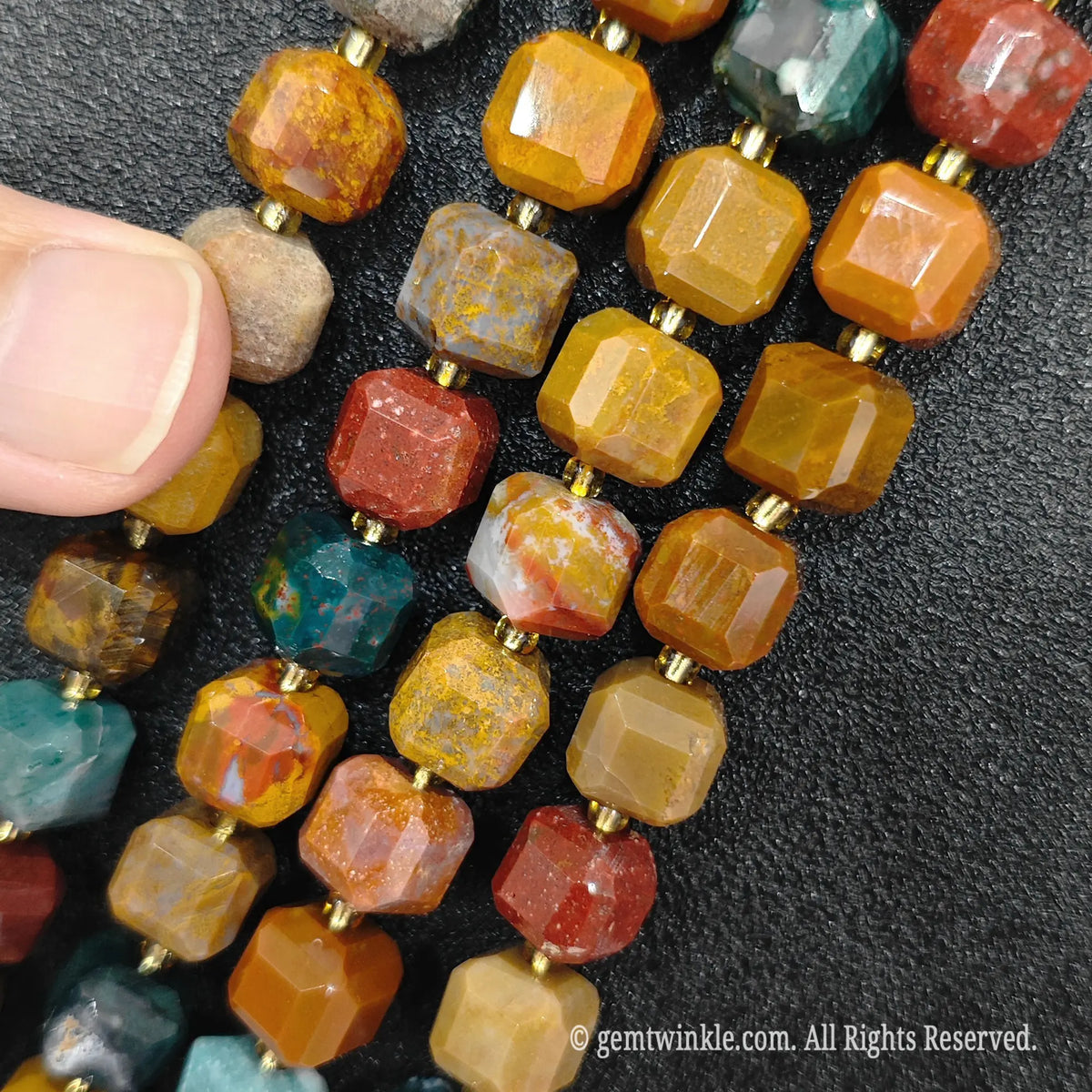 Fingers holding natural ocean jasper soft square gemstone block beads to show scale and proportion