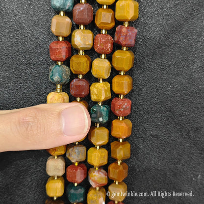 Detailed macro view of natural ocean jasper geometric cube beads showcasing multi-color orbicular patterns