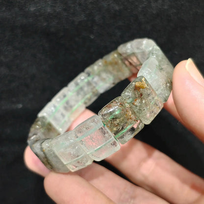 Natural opaque green phantom quartz smooth block tile stretch bracelet held on hand displaying milky opaque matrix and green chlorite specks